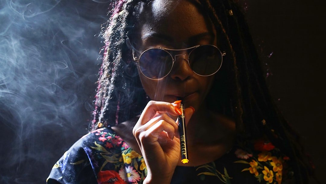 Woman inside with sunglasses pulls on and exhales the Clear disposable pen. This vape cartridge contains the purest ultra-premium cannabis distillate available to adults in the Colorado market. Get your THC vape pen from The Clear at https://theclearbrands.com/